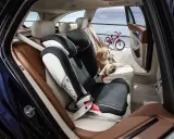Czy fotelik z isofix można zamontować pasami? Tak, ten fotelik jest zamontowany pasem samochodowym, obok siedzi pluszowy miś.