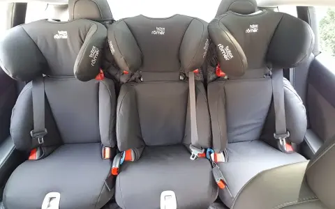 Trzy foteliki Britax Römer na tylnej kanapie. Dowiedz się, jak zamontować fotelik na środku tylnej kanapy, by zapewnić bezpieczeństwo.