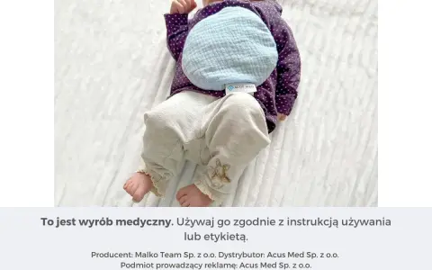 Niemowlę z termoforem z pestek wiśni na brzuszku. Dowiedz się, jak zagrzać taki termofor, by przyniósł ulgę.