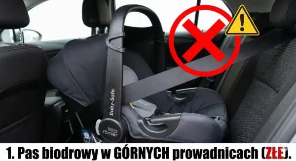 Błąd w montażu: pas biodrowy fotelika w górnych prowadnicach. Zobacz, jak zamontować otulacz do fotelika bezpiecznie.